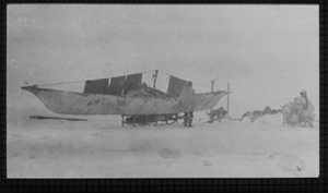 Image of Whale boat (umiak) on sledge, blankets hanging (Shipwreck Camp)
